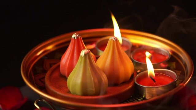 Close-up shot in slow motion. Ladu modaka dessert for Lord Ganesha on a tray ready to be worshiped. indian sweets