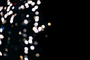 Colorful abstract bokeh made from Christmas lights on black isolated background. Holiday concept,...