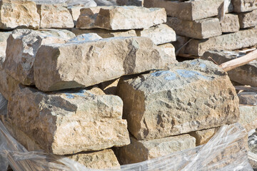 Pile of old sandstone slabs ready to be mounted in a new pavement in a urban construction site