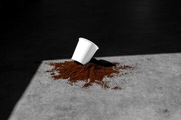 Blank coffee paper cup in a pile of grounded coffee, on concrete background, with sharp natural...