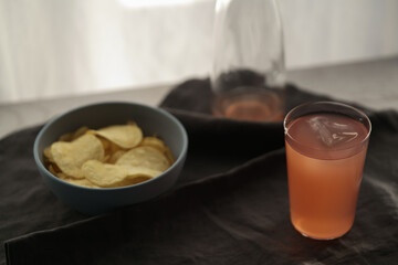 Pink drink with potato chips in a bowl on linen napkin