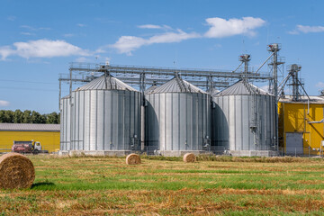 Fototapeta na wymiar Agro silos granary elevator with seeds cleaning line on agro-processing manufacturing plant for processing drying cleaning and storage of agricultural products in rye corn or wheat field