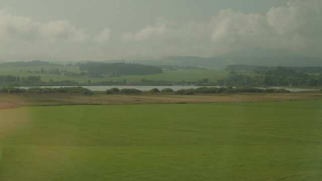 train passing beautfiul Salzburg country landscape near Wallersee