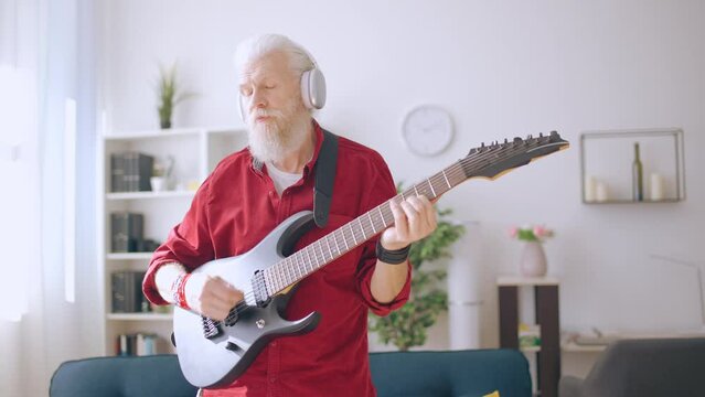 Senior man playing electric guitar, trendy grandpa, forever young, rock and roll