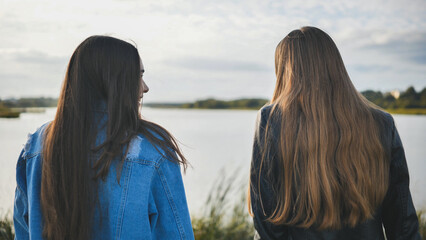 Two friendly friends sit and cuddle by the lake.