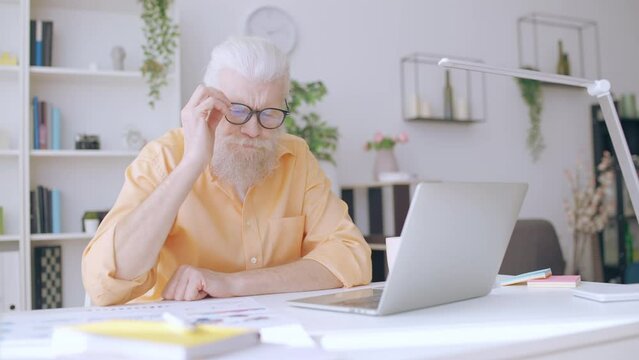 Senior man receiving email with bad news, work project failure, getting fired