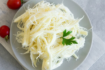 Turkish traditional homemade checil or string cheese on plate, healthy dairy product