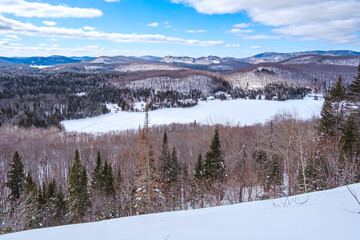 View in winter on the snow covered mountains of Laurentides from the top of Mount Kaaikop in Quebec (Canada)