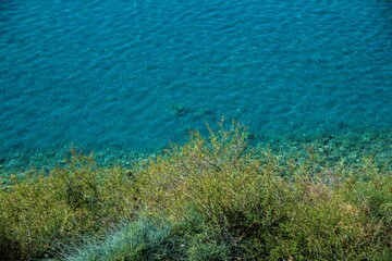 Fototapeta na wymiar cliff covered in grass on the water's edge at Lake Ohrid in North Macedonia