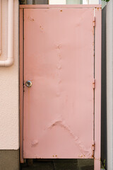 建物の裏へ繋がるピンク色の扉