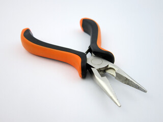 Obraz premium Flat-nosed pliers with orange and black handles on a white background. 