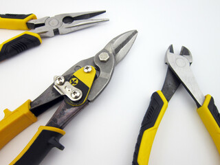 metal cutting scissors and assorted pliers on a white background                 