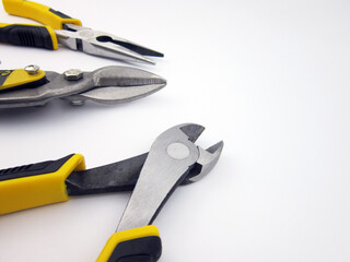 metal cutting scissors and assorted pliers on a white background                 