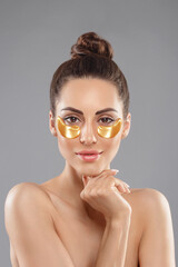 Woman With Under Eye Collagen Gold Pads, Beauty Model Girl Face With Healthy Fresh Skin. Skin Care Concept, Anti-Aging Moisturizing Eye Mask
