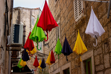 Colorful umbrellas hanging above an old alleyway