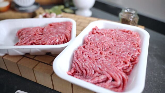 White plastic containers with mince on kitchen work place, variety of ingredients prepared for cooking home burgers, cookery concept