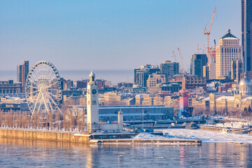 Winter view on the big wheel, the clock tower and the old port of Montreal early in the morning from Jacques Cartier bridge (Quebec, Canada)