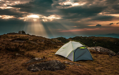 Tent camping on the mountains at the sunset and sunrise landscape with clouds and sun feeling...