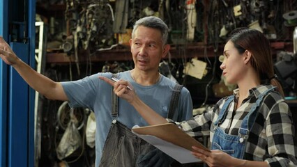 Asian Female trainee Mechanics and senior car engineer Working  Together at Car maintenance and auto service garage. Car maintenance and auto service garage concept.