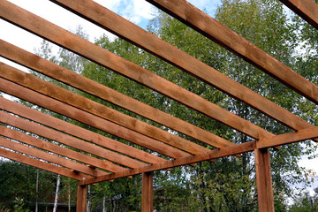 The process of building a wooden canopy from brown boards in the rural place in summer day