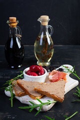 Grilled sandwich with pate with chicken liver and olives on dark background
