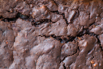 Top view of surface of cracked sugar crust of dark chocolate brownie background and texture, close up