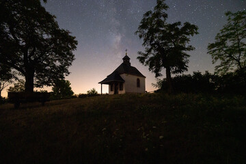 Obraz premium Milchstraße Sternenhimmel über Kirche Kapelle Kleine Kalmit im Sternenpark Pfälzerwald