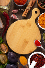 Variety of spices and herbs wood cutting board at table background. Cooking concept and ingredients