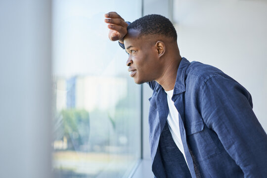 Young African American Man Looking Out The Window In An Office