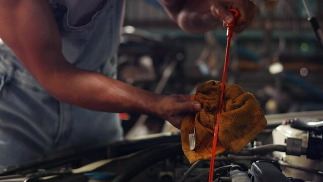 Closeup hand and spanner. Auto car mechanic checking the oil level of the car engine.
