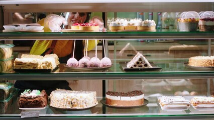 Concept of small business restaurant and cafe saleswoman take some deserts from the showcase fridge to selling in the bakery cafe
