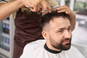 Obraz na płótnie Canvas Pleasant guy having a fresh haircut at modern hair salon
