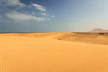 Fototapeta na wymiar fuerteventura beach with its famous desert sand dunes, corralejo, mount tindaya in the background, estino volcano