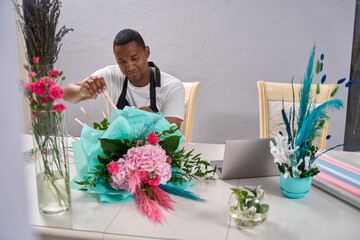 Young guy making a bouquet of flowers