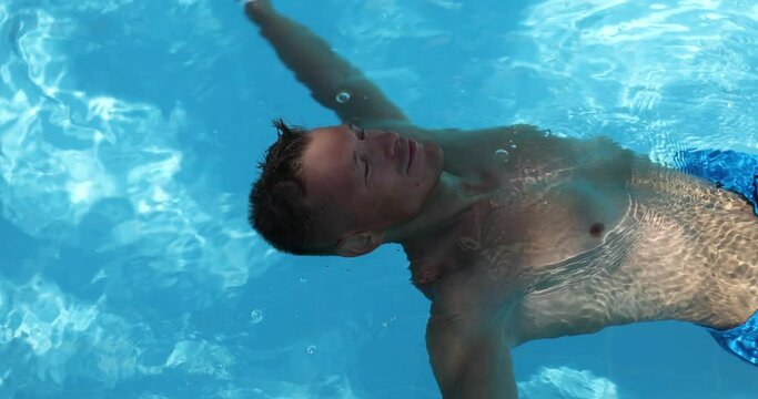 The guy in the pool lies on his back with his arms outstretched