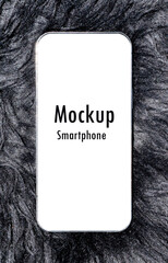Smartphone with mockup white screen and clipping path on black wool rug