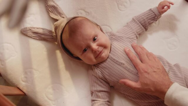 Close up cute charming newborn little hand reaching for father's loving finger. Baby holding parents finger. Smiling. Parentheses. Child. Slow motion