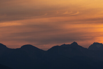 Silhouetted Western Ridge With Whispy Clouds Over Glacier