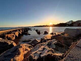 fotografía de un atardecer visto desde el mar hacia la costa