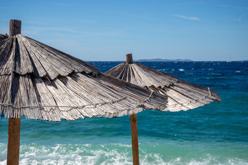 Two sunshades on the beach in Croatia. Blue sea and sky in the background.
