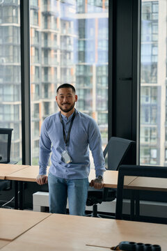 Happy corporate manager posing for camera in workplace