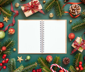 Fototapeta na wymiar Blank open notepad on a green background near Christmas decorations and fir branches