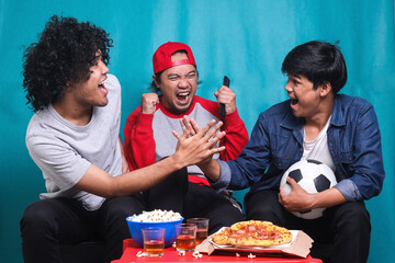 Happy friends or football fans watching soccer on tv and celebrating victory. Friendship, sports and entertainment concept.