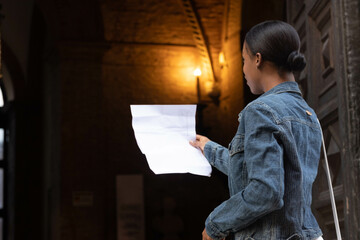 Portrait of African American woman dressed in white and denim jacket, getting to know Europe,...