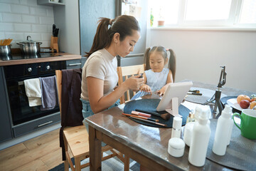 Young blogger female asian in kitchen paints the girl nails