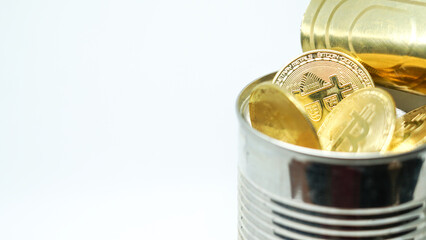 Monedas de Bitcoin dentro de un bote de conserva asomados al borde del bote