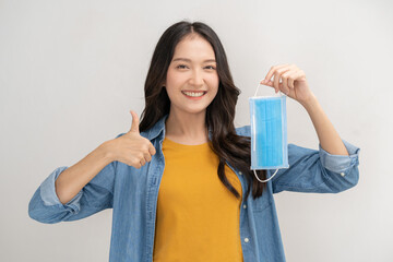 Portrait of cheer up asian young womon hand in thumb up, take off mask after getting anti virus...