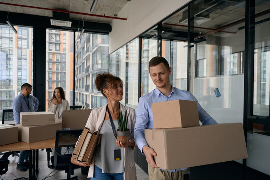 Young company workers packing for office move