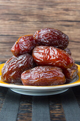 Delicious medjool dates ( kurma ) or sweet dried dates on a plate, as a meal for breaking the fast, ramadan kareem, empty space, copy space.