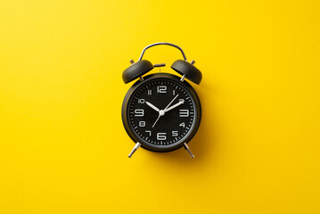 Fototapeta Black friday concept. Top view photo of black alarm clock on isolated yellow background obraz